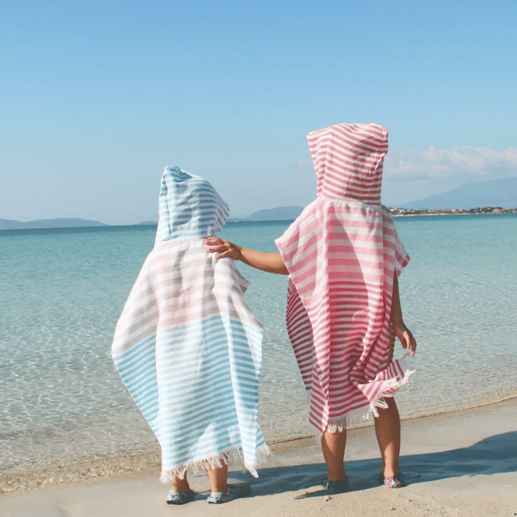 Ipanema Kids Poncho Towel in pink, made from 100% cotton, featuring a hood and packaged in a recycled gift box.